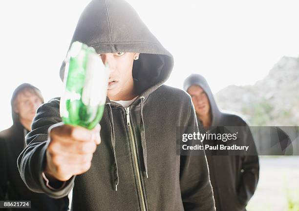 man wielding broken bottle - broken bottle fight stock pictures, royalty-free photos & images