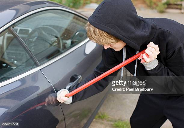 burglar prying car window open with crowbar - thief stock pictures, royalty-free photos & images