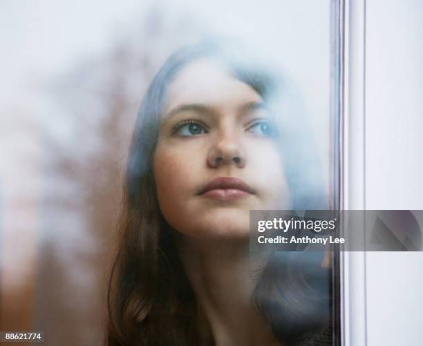 girl looking out window - pre adolescent child stock pictures, royalty-free photos & images