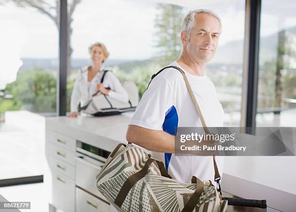 man carrying tennis racquet in gym bag - bradbury house stock pictures, royalty-free photos & images