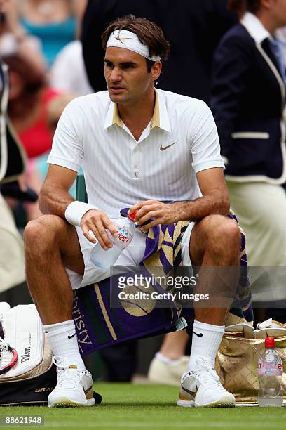 Roger Federer of Switzerland takes a break during the men's singles first round match against Yen-Hsun Lu of Chinese Taipei on Day One of the...