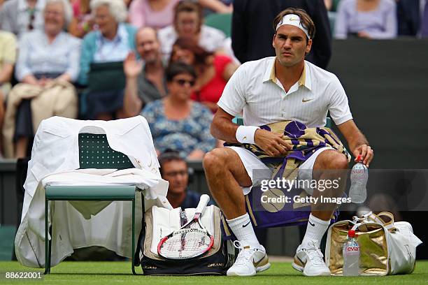 Roger Federer of Switzerland takes a break during the men's singles first round match against Yen-Hsun Lu of Chinese Taipei on Day One of the...