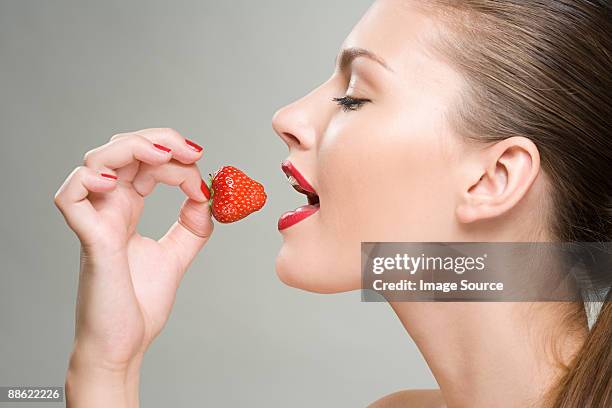 a woman eating a strawberry - female open mouth stock pictures, royalty-free photos & images