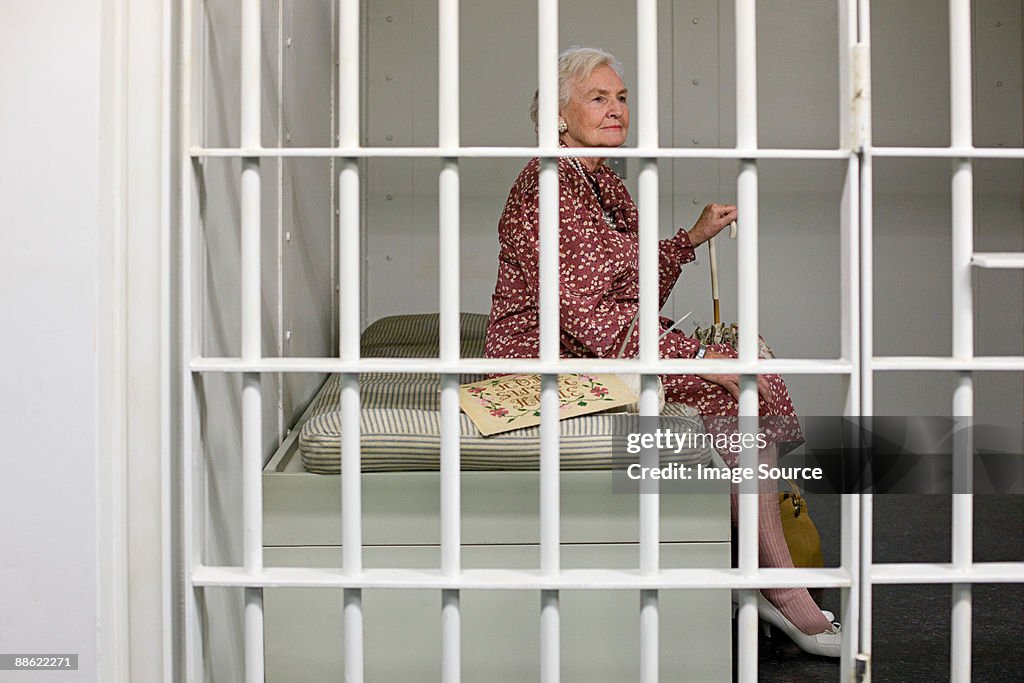 Senior woman in prison cell