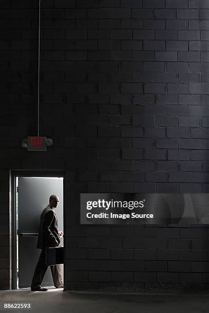 businessman going through door - uitgang stockfoto's en -beelden