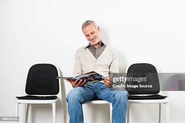 man in waiting room - patients in doctors waiting room stockfoto's en -beelden