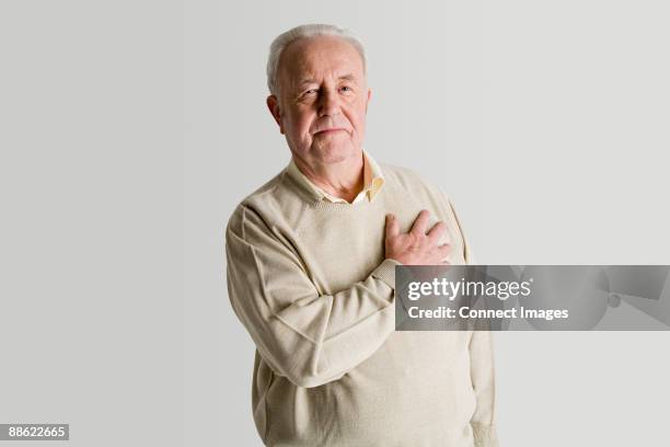 senior man with hand on heart - man with hands on chest stock pictures, royalty-free photos & images