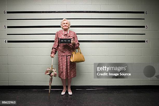 mugshot of senior woman - criminal stock-fotos und bilder