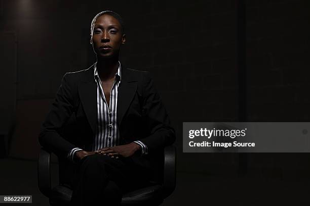 businesswoman in chair - corporate dark portrait stock-fotos und bilder