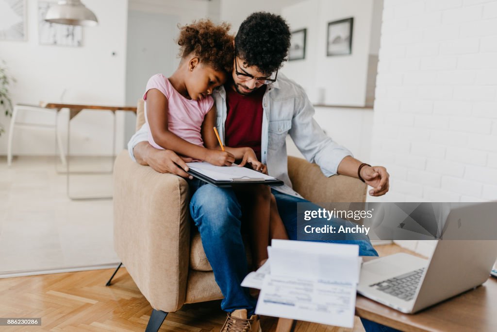 A cute girl tries to cheer up her father with her drawings