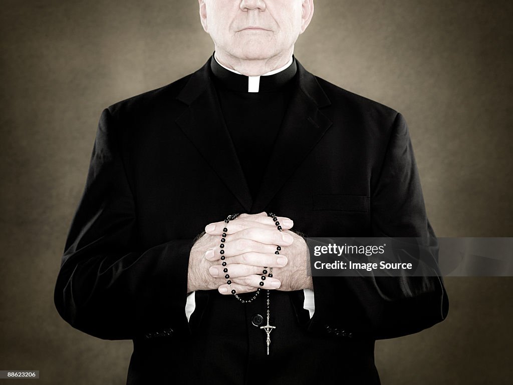 A priest holding prayer beads
