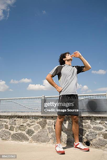 runner drinking - running shorts stockfoto's en -beelden