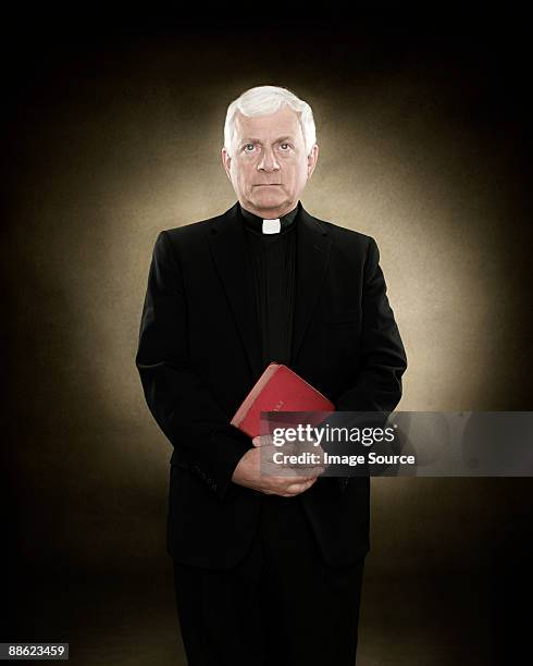 portrait of a priest holding a bible - priest photos et images de collection