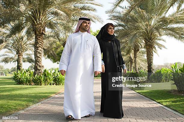 a couple walking in a park - emirati couple stock pictures, royalty-free photos & images