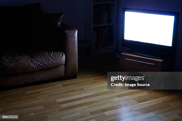 a tv on in a living room - living room television stock-fotos und bilder