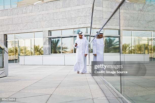 businessman using cell phone - city walk dubai stockfoto's en -beelden