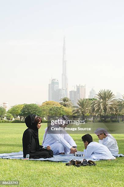 a family sat in a park playing chess - dubai park stock pictures, royalty-free photos & images