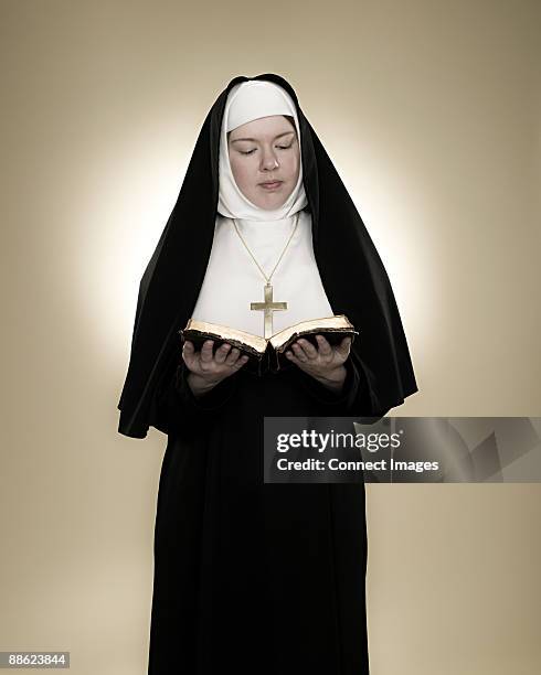 a nun reading a bible - monja fotografías e imágenes de stock