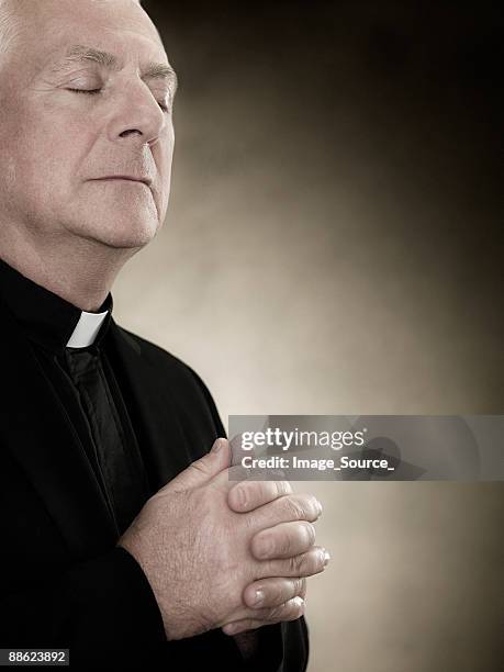 a priest praying - catholic priest stock pictures, royalty-free photos & images