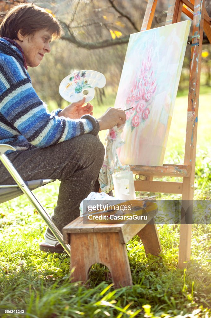 Senior Woman Artist Painting Artwork on Canvas