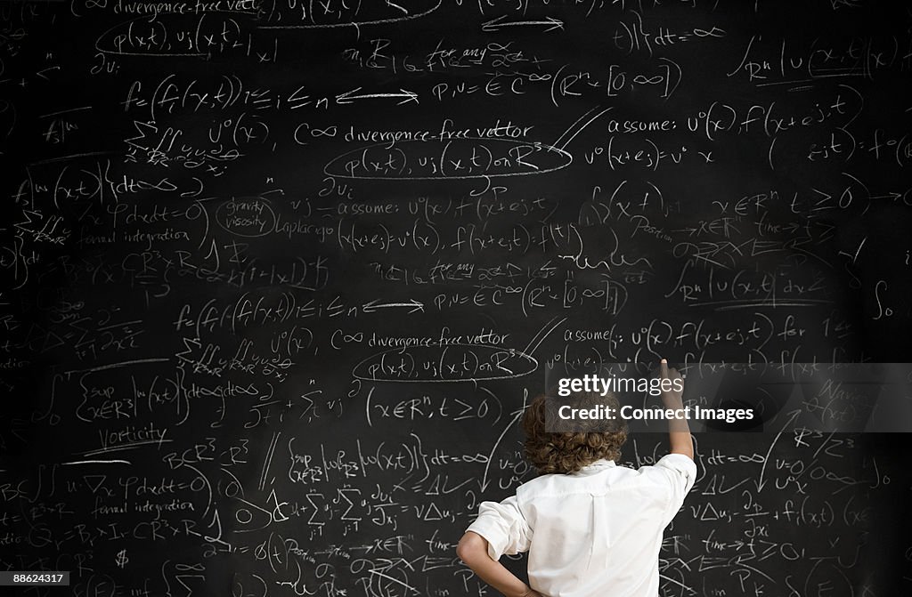 Boy with formulae on blackboard