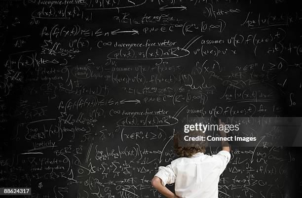 boy with formulae on blackboard - mathematische formel stock-fotos und bilder