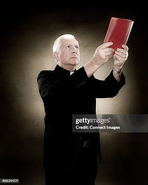 ein priester hält eine bibel - priesterkragen stock-fotos und bilder