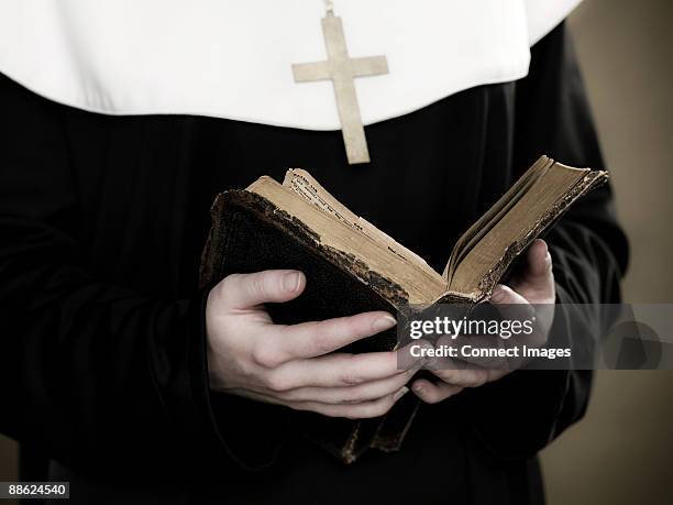 a nun holding a bible - monja fotografías e imágenes de stock