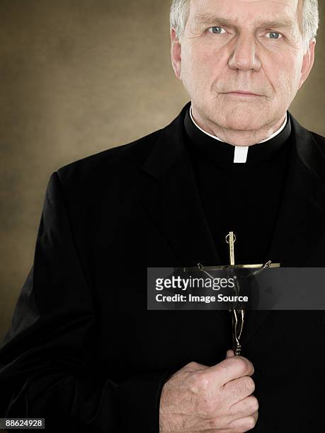 a priest holding a crucifix - cuello clerical fotografías e imágenes de stock