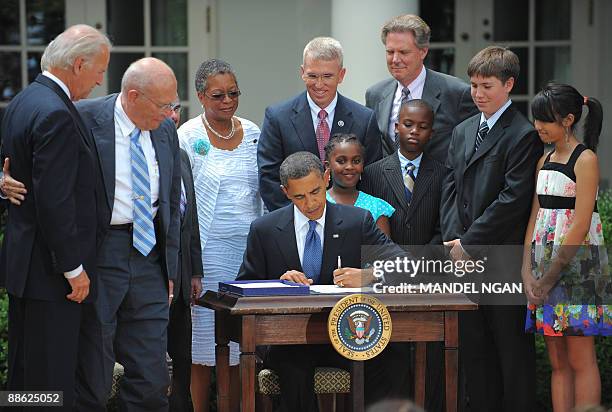 President Barack Obama signs the Family Smoking Prevention and Tobacco Control Act as Vice President Joe Biden , Rep. John Dingell , D-MI, and...