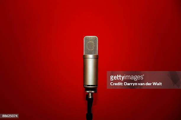 microphone against a red background - colour microphone stock-fotos und bilder