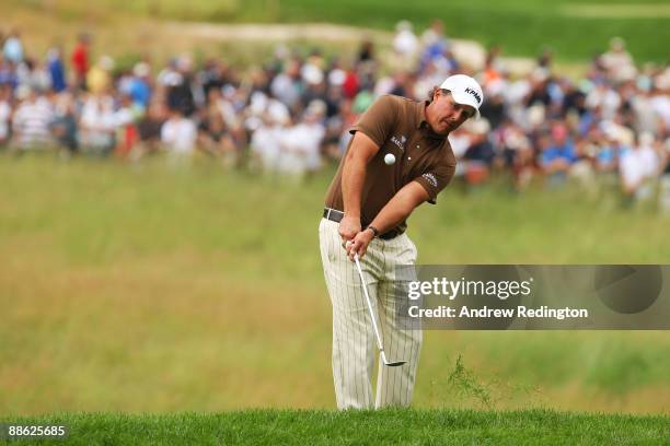 Phil Mickelson pitches to the 17th green during the continuation of the final round of the 109th U.S. Open on the Black Course at Bethpage State Park...