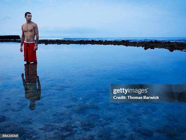 man standing in ocean at sunrise looking away - ankle deep in water stock pictures, royalty-free photos & images