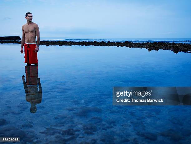 man standing in ocean at sunrise looking away - ankle deep in water - fotografias e filmes do acervo