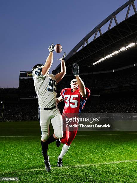 professional football receiver making catch - american football player catch stock pictures, royalty-free photos & images