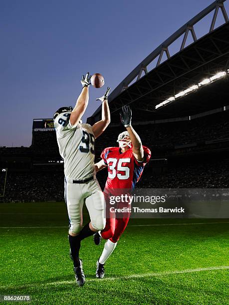 professional football receiver making catch - jogador de futebol americano imagens e fotografias de stock