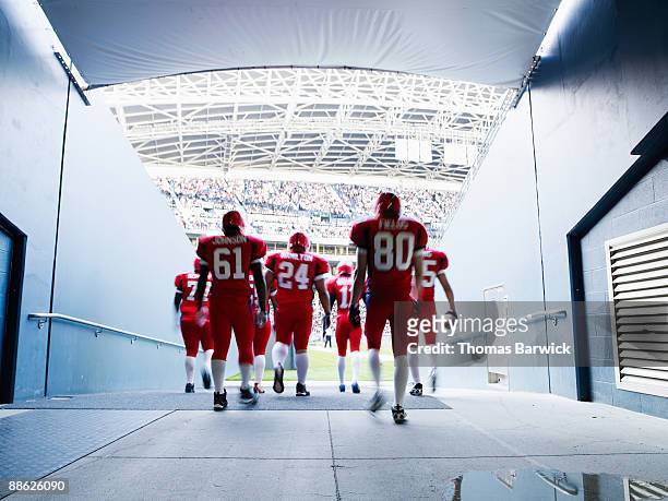 football team walking out to crowded stadium - football player tunnel stock pictures, royalty-free photos & images
