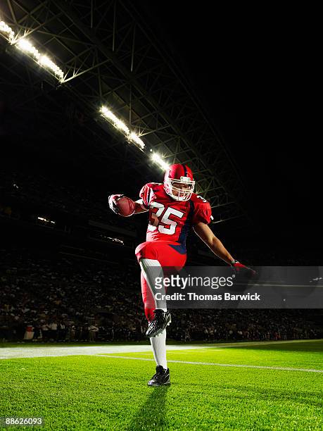 football player celebrating in end zone - touchdown stock pictures, royalty-free photos & images