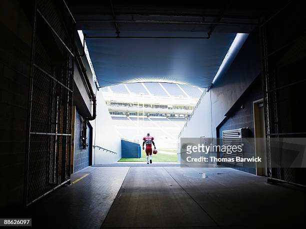 professional football player walking into stadium - forward athlete stockfoto's en -beelden