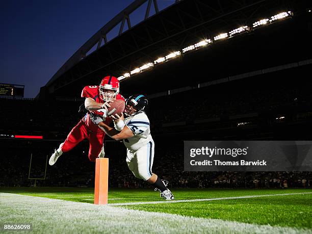 football player diving into end zone - football spieler stock-fotos und bilder