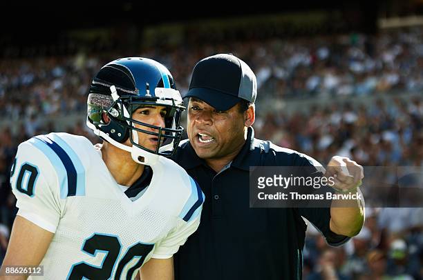 football coach motivating player on sideline - coach stock pictures, royalty-free photos & images