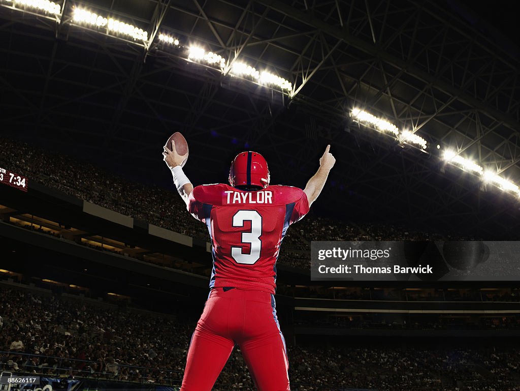 Professional football player celebrating arms up