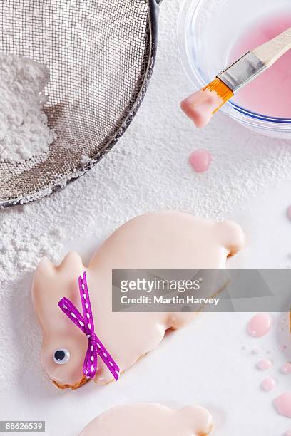 easter bunny shaped biscuits getting iced - straining spoon stock pictures, royalty-free photos & images