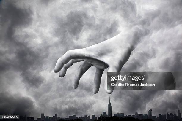 menacing hand looming over city - jugement dernier photos et images de collection