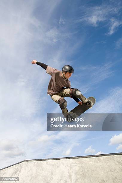 a male skateboarder catches some air. - casco de deportes fotografías e imágenes de stock