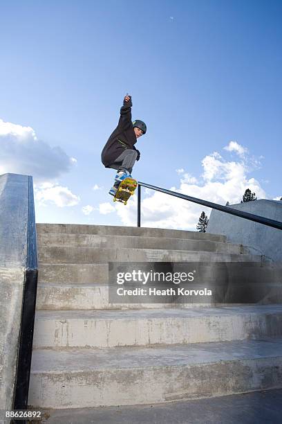 a skateboarder jumps a set of stairs. - railings ストックフォトと画像