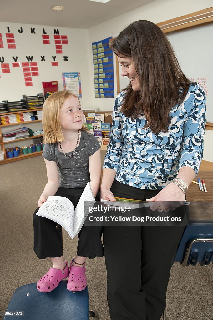 Elementary School Teacher Helping Student