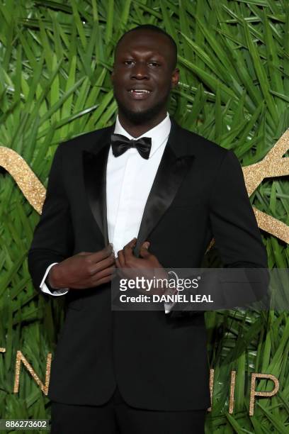 English grime and hip hop artist Stormzy poses on the red carpet upon arrival to attend the British Fashion Awards 2017 in London on December 4,...