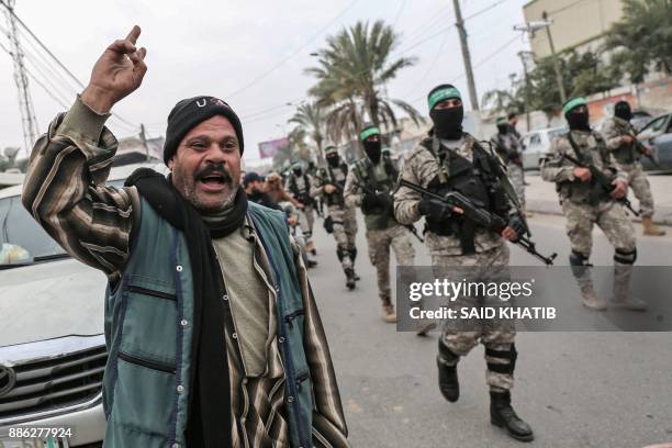 Palestinian shouts slogans as fighters from the Ezzedine al-Qassam Brigades, the armed wing of the Palestinian Hamas movement, march past in the...