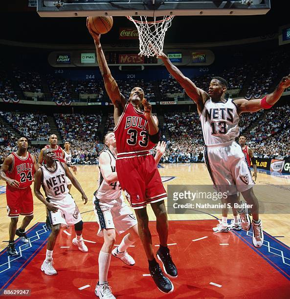 Scottie Pippen of the Chicago Bulls shoots a layup against Kendall Gill of the New Jersey Nets in Game Three of Eastern Conference Quarterfinals...
